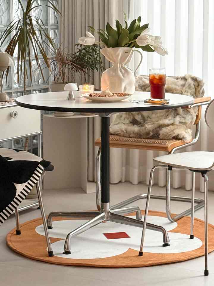 White and wood tone dining room with round table featuring home cafe elements, creating a cozy atmosphere