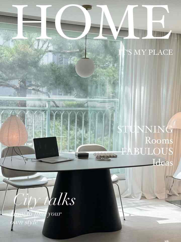 白と黒を基調としたリビング兼ダイニングルーム、大きな窓とシンプルなダイニングテーブル、椅子、テーブルランプが配置された雰囲気のある空間