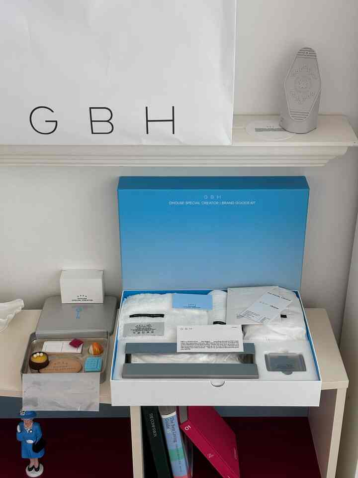 ホワイトとブルーのトーンの棚の空間、シンプルなオブジェとパッケージが配置されたモダンでミニマルな雰囲気のインテリア