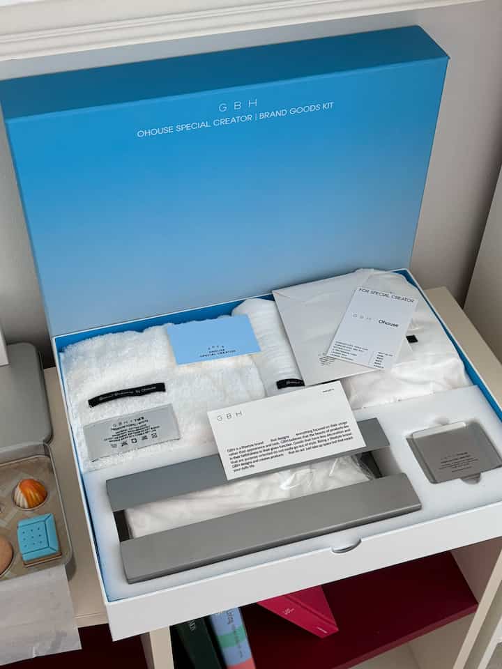 白とシルバーのトーンのブランドグッズキットボックス、タオルとステンレス製品がすっきりと配置されたイメージ