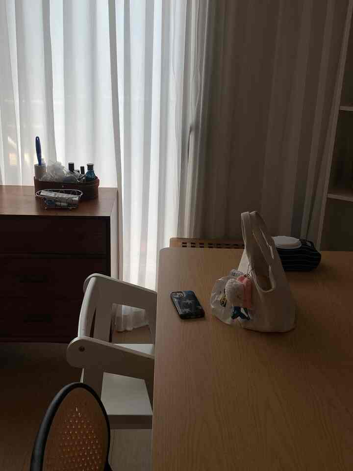 木目調と白いカーテンが調和したダイニング、シンプルで落ち着いた雰囲気のインテリア