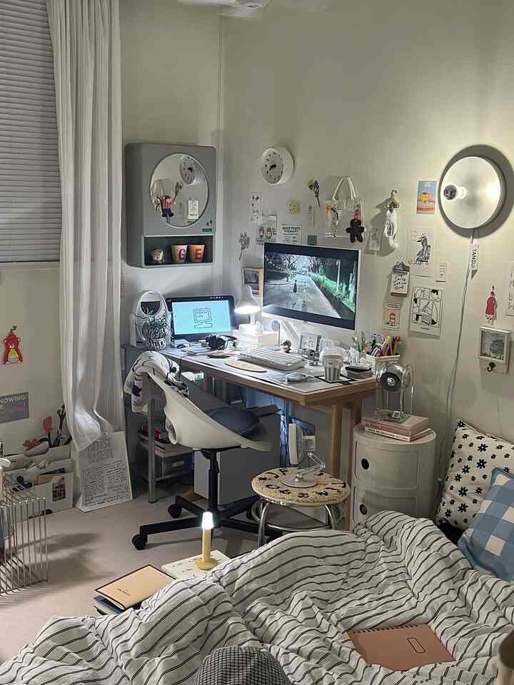 ホワイトトーンの寝室兼ホームオフィス、デスクとオフィスチェア、居心地の良い寝具が配置された雰囲気のある空間