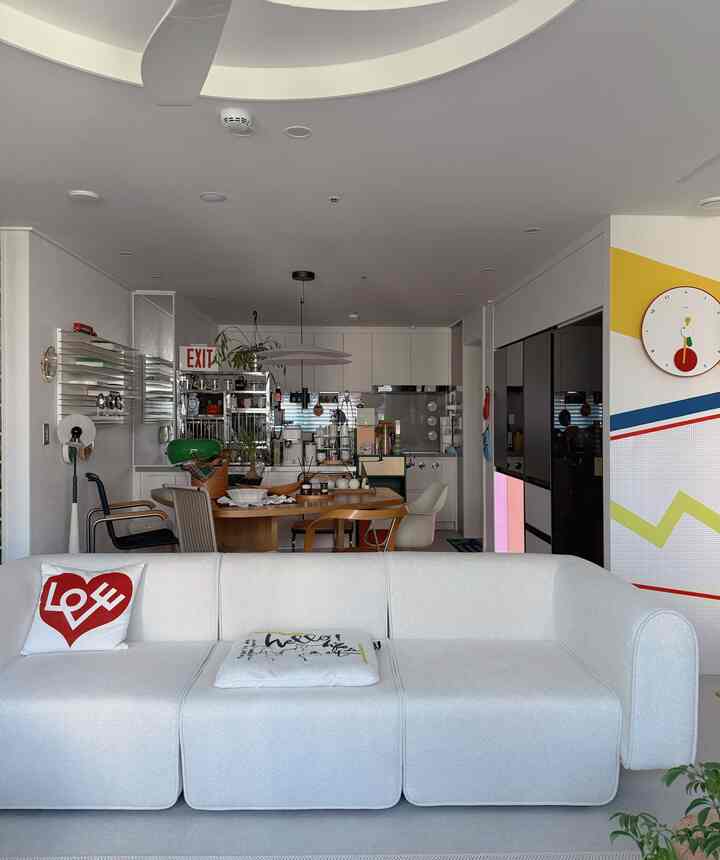 ホワイトとモダンな色調のリビング、広いソファと円形ダイニングテーブルが配置された明るく洗練されたインテリア