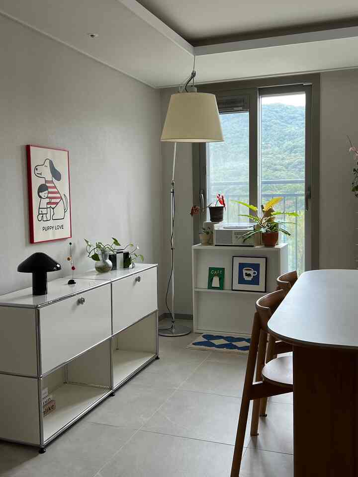 ホワイトとウッドトーンの調和が取れたリビング、6人用ダイニングテーブルとサイドボード、フロアランプが配置された自然で清潔感のあるインテリア