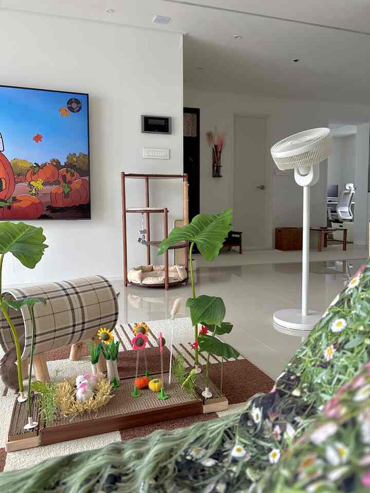 Living room with white floor tiles and natural brown rug, featuring cat tower and tunnel in a pet-friendly setting