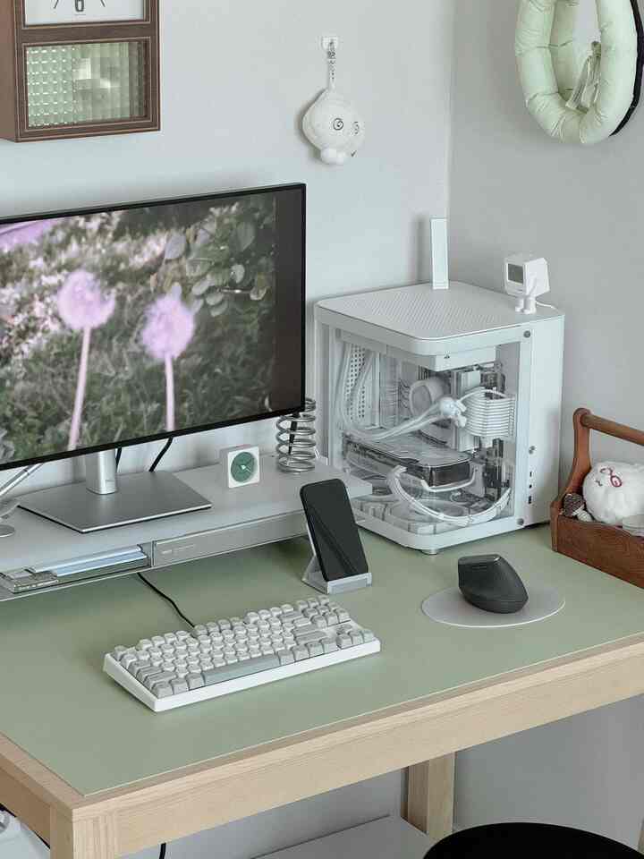 白と木目調が調和したミニマルなホームオフィス、整頓されたデスクにコンピュータと周辺機器が配置されている雰囲気のあるインテリア