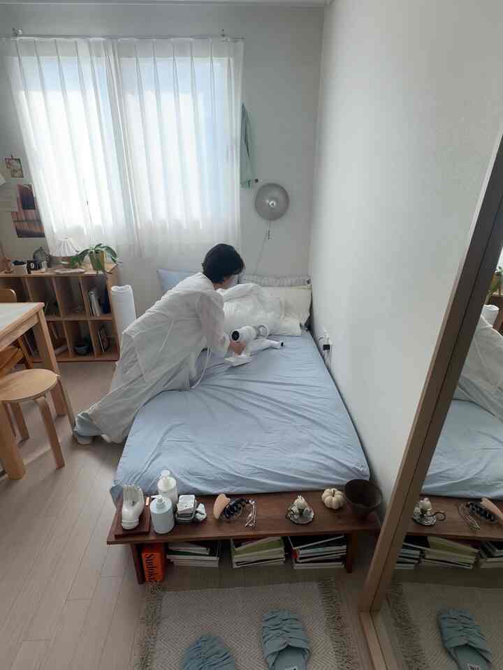 柔らかなスカイブルーと木目調が調和した縦長の一人暮らし用寝室、清潔感と自然な雰囲気のあるインテリア