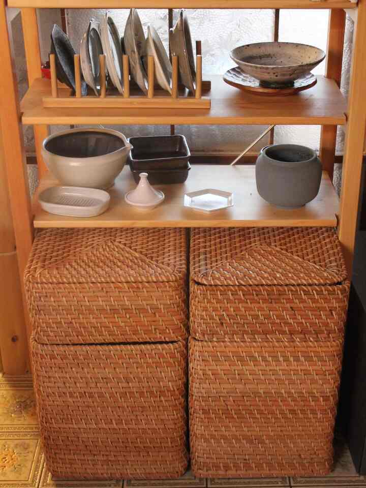 ナチュラルカラーの木目調キッチン棚、ラタンバスケットと整然としたテーブルウェア収納のある雰囲気の良いインテリア