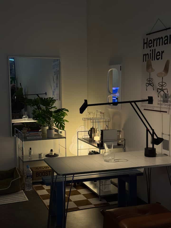 白と黒のトーンのダイニングルーム、テーブルランプと花瓶、植物が配置されたモダンな空間