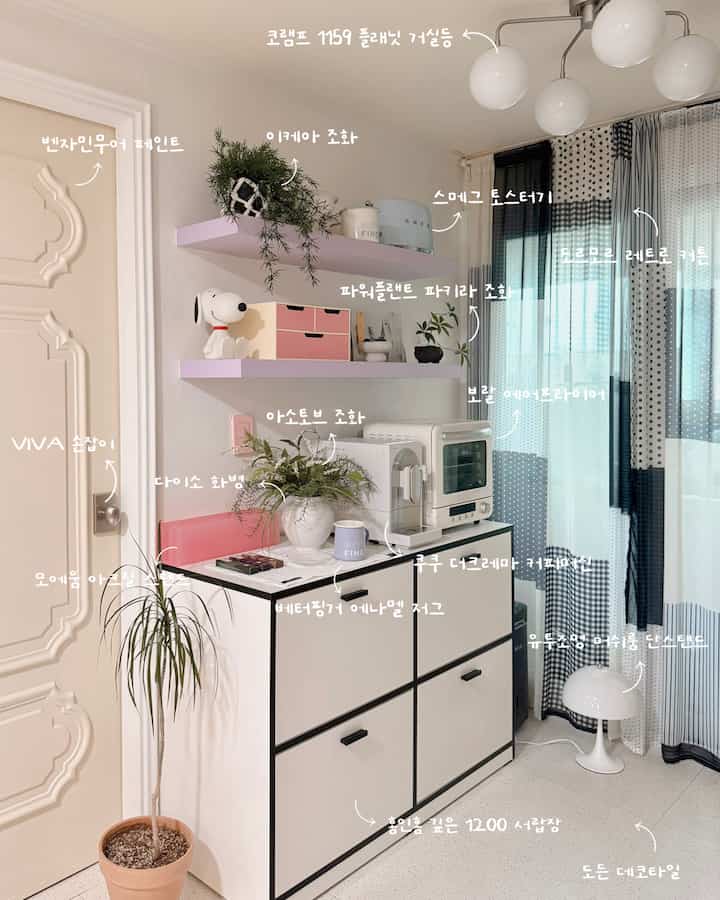 白と黒を基調としたコンパクトなキッチン、収納キャビネットやコーヒーマシン、自然な植物が配された雰囲気のあるインテリア