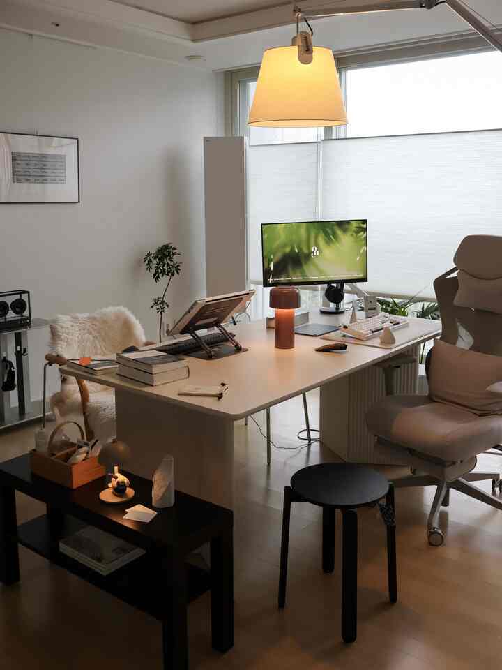 白と木目調が調和したホームオフィス空間、大きなデスクと人間工学チェアが配置されたミニマルなインテリア