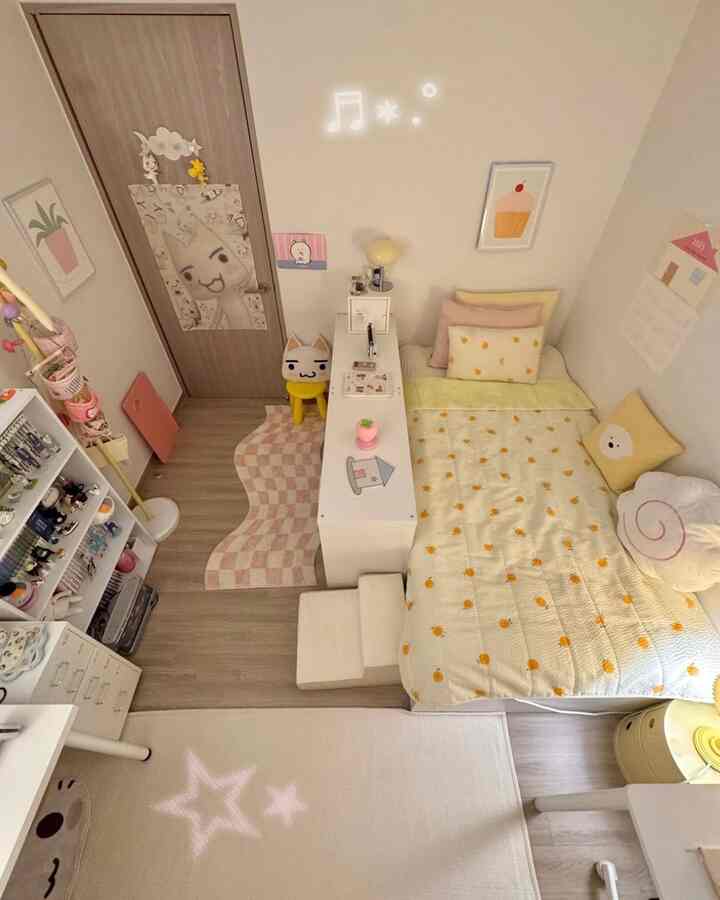 ピンクと黄色の色調が映える子供部屋、ベッドと机、おもちゃ棚が配された印象的で居心地の良いインテリア