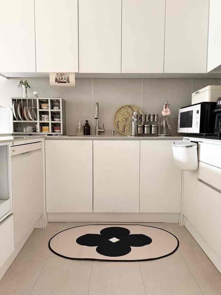 白を基調としたキッチン、整頓された収納とモダンなデザインが調和するコンパクトな空間