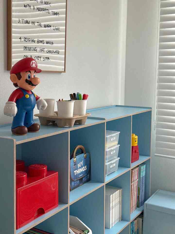 スカイブルーの本棚が配置された子供部屋、玩具や本が整理された印象的な空間