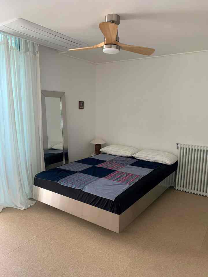 白とシルバーのトーンの寝室、シルバーのベッドフレームとブルーのブランケットが映える印象的な空間