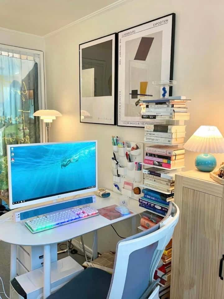 白と青を基調としたホームオフィス、机とコンピュータ、本棚が配置された居心地よく機能的な作業空間