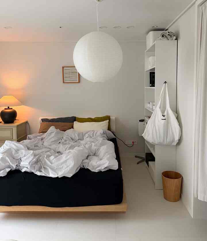 White and brown toned bedroom featuring a centrally placed bed and nightstand with a natural, modern atmosphere