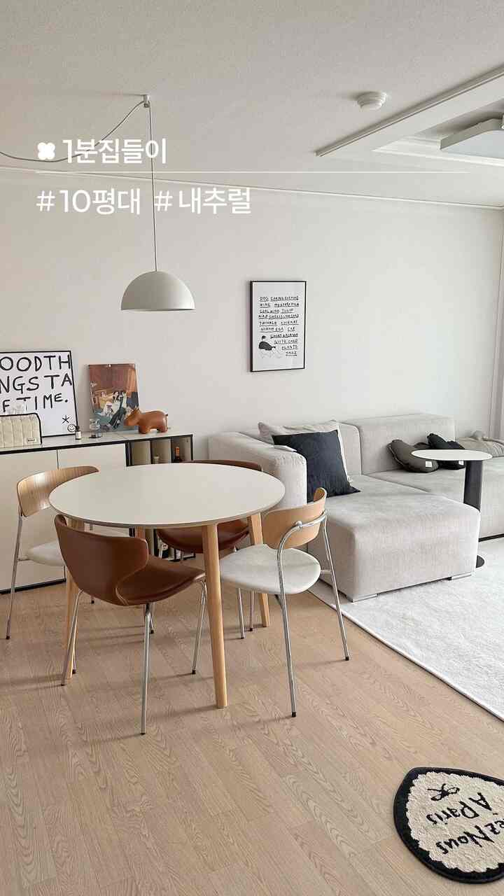 白と木目調の10坪のリビング兼ダイニング、丸テーブルとベージュのソファが配置されたシンプルでナチュラルな印象の空間