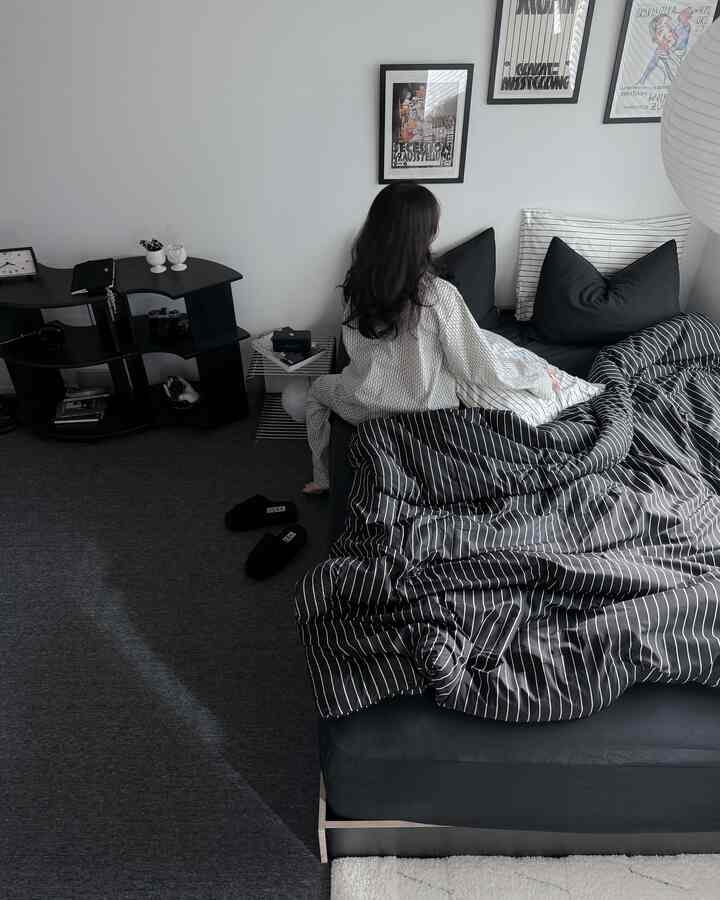 黒と白のモノトーン寝室、中央にベッドと寝具が配置されたシンプルで清潔感のある空間