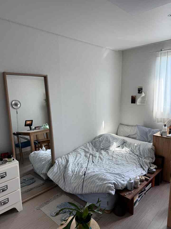 白い壁とナチュラルな木製家具が配置された6畳の寝室、シンプルで居心地の良い空間