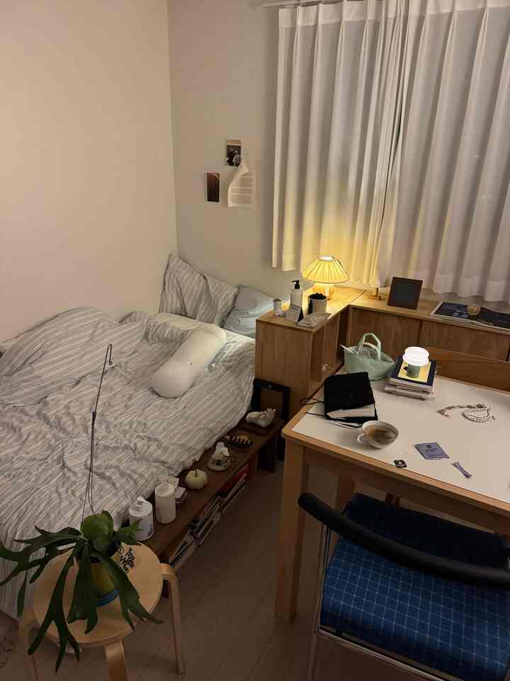 ホワイトとナチュラルカラーの6畳寝室、ベッドとデスクが配置された居心地の良い一人暮らしの空間