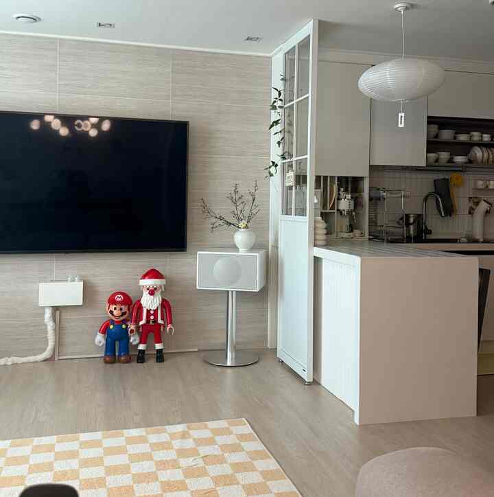 白とベージュの色調のリビングとキッチン、チェッカーボードのラグと大きな装飾フィギュアが配置されたモダンなミッドセンチュリーモダンのインテリア