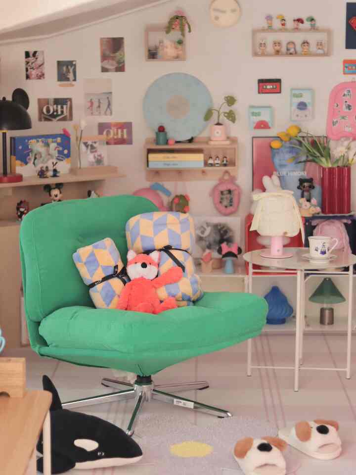 明るい緑色のアームチェアとカラフルなおもちゃが配置された、子供部屋のような遊び心のあるリビングスペース