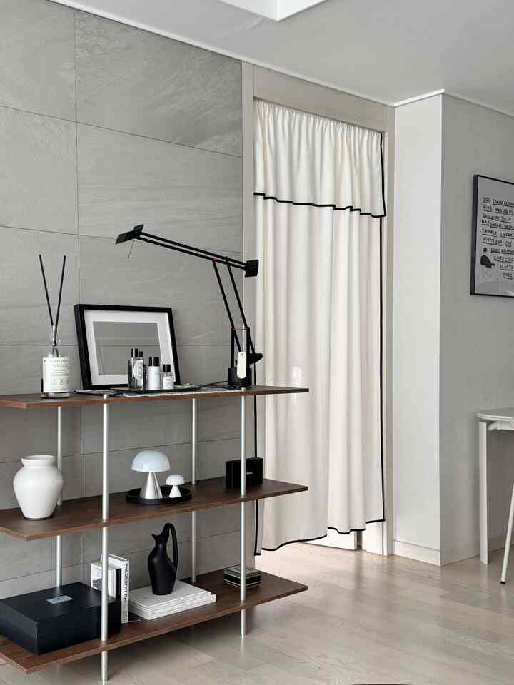 ナチュラルな色調のリビング、木製の棚とシンプルな照明が配置された雰囲気のあるインテリア