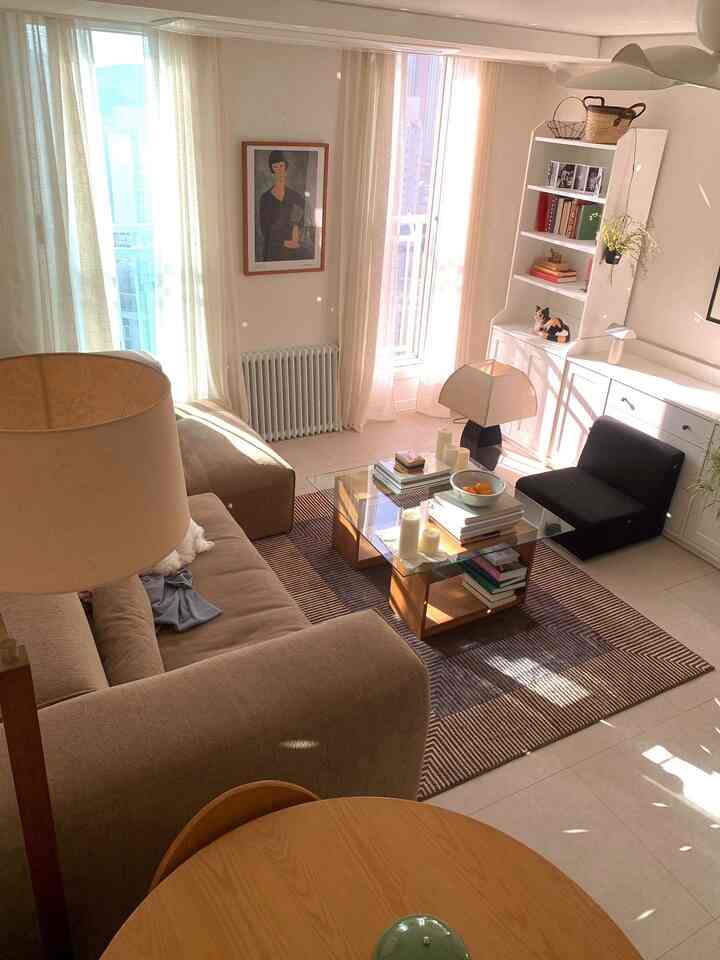 暖かいベージュと白の色調のリビング、ソファとコーヒーテーブル、犬がいる居心地の良い空間