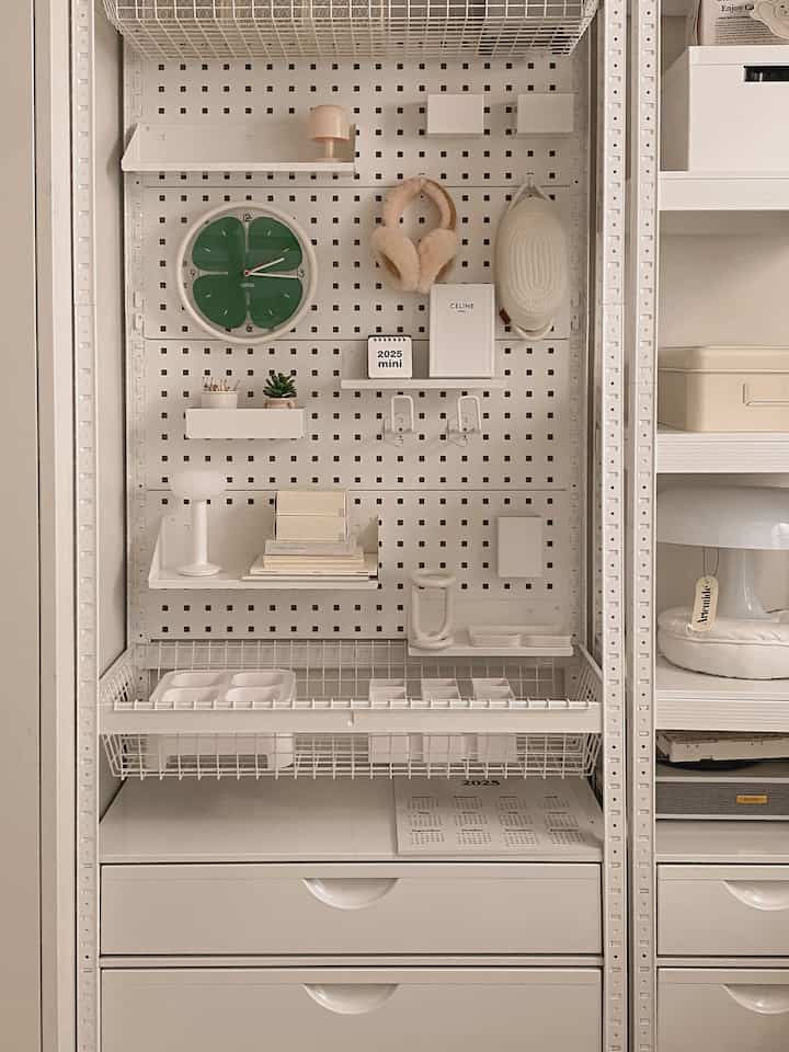 白を基調とした収納棚と壁掛けモジュールが配置された、すっきりとしたミニマルな空間