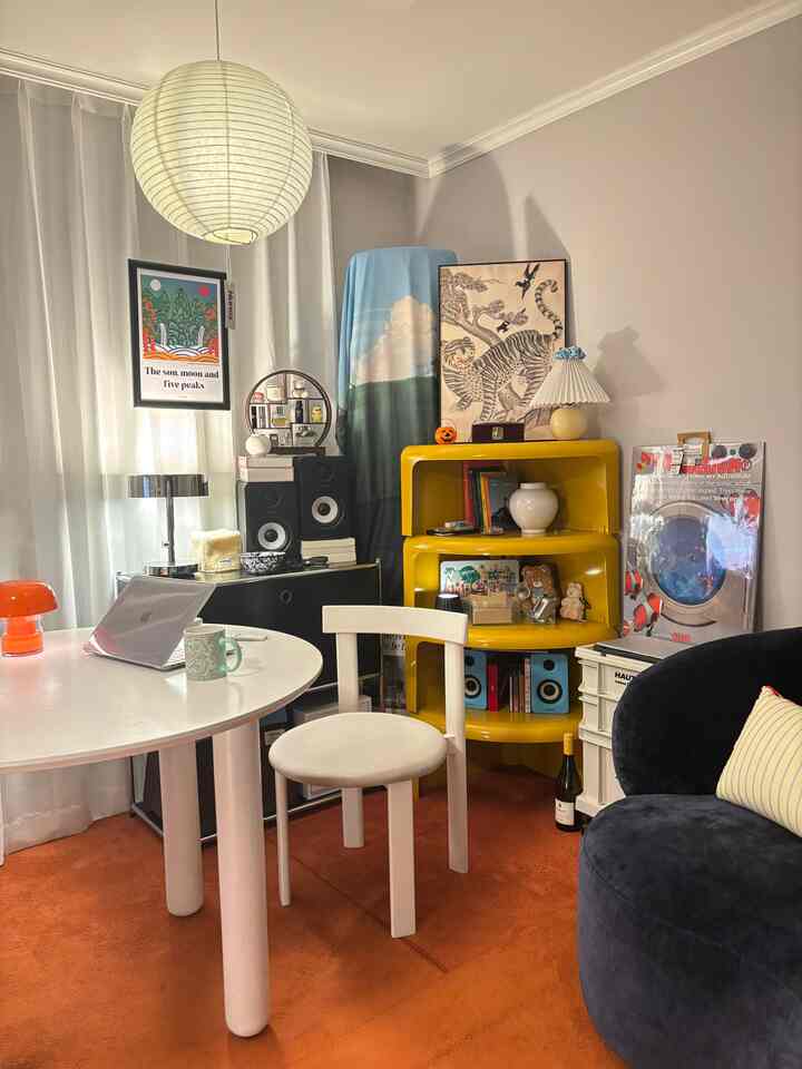 白とオレンジの色調が調和するワンルームのホームオフィス、モダン家具と韓国風インテリア小物が配置された雰囲気のある空間