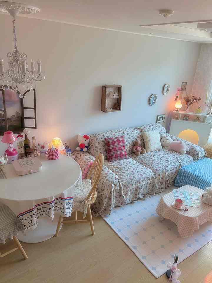 柔らかなベージュ色とフラワーパターンが調和したリビング、丸いダイニングテーブルと居心地の良いソファが配置された雰囲気のあるインテリア