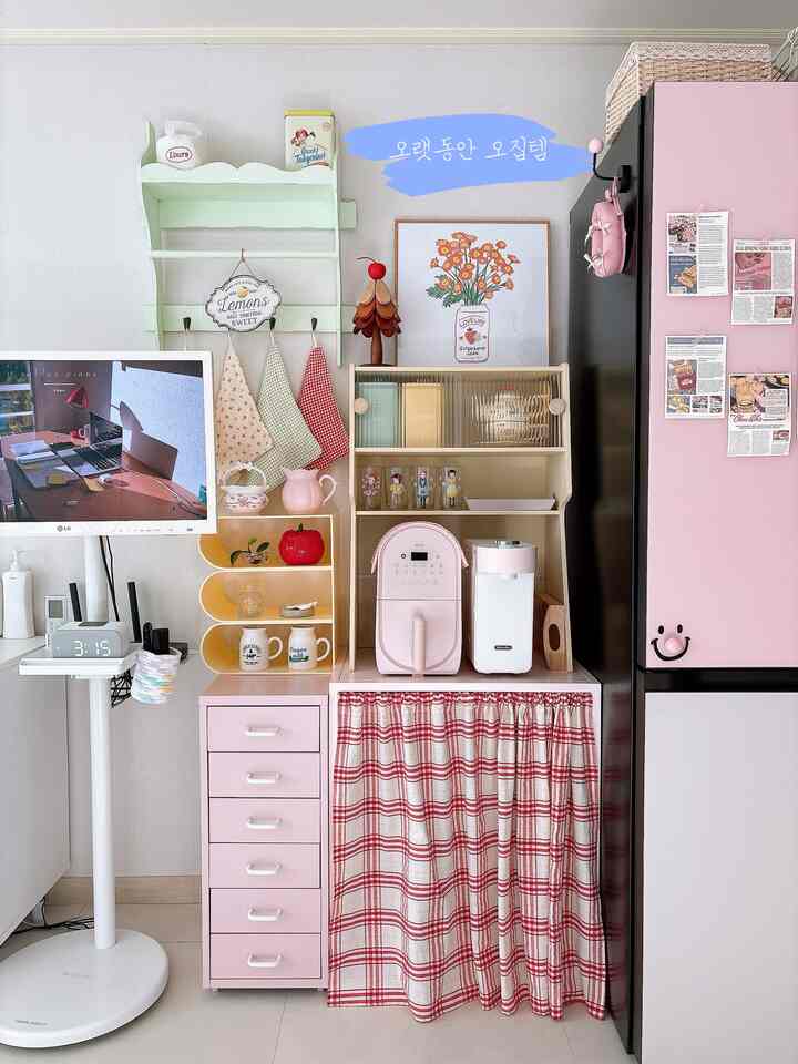 ピンク色調のキッチン、コーヒーマシンや多様な収納が配置された印象的で居心地の良いインテリア