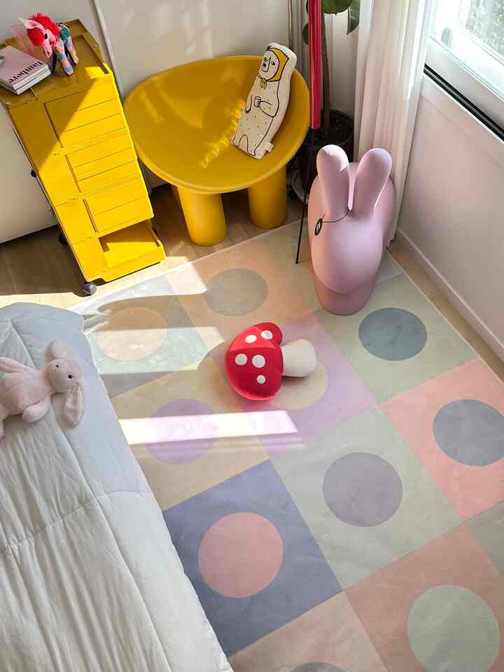 黄色の寝室、モダンなイエローのアームチェアとカラフルなラグ、クッションが配置された雰囲気のある子供部屋