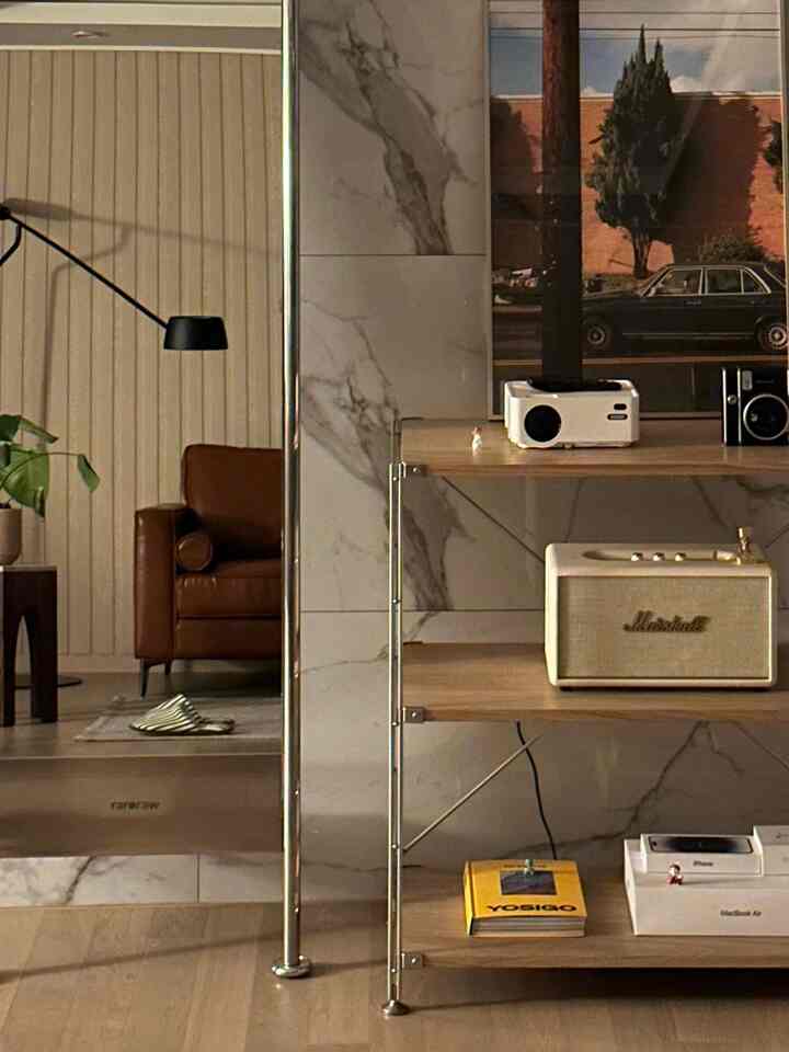 ブラウンレザーのソファと無印良品の棚が配置されたミッドセンチュリーモダンのリビングルーム