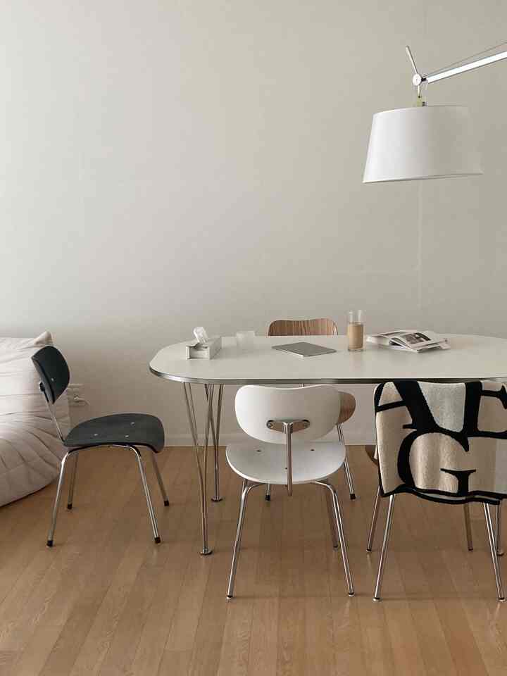 白と木目調が調和したシンプルモダンな4人用ダイニング、清潔感あるレイアウトと印象的な照明の空間