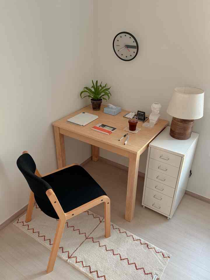 ウッド調とホワイトのホームオフィス、シンプルなデスクとブラックの椅子が配置された落ち着いた作業空間