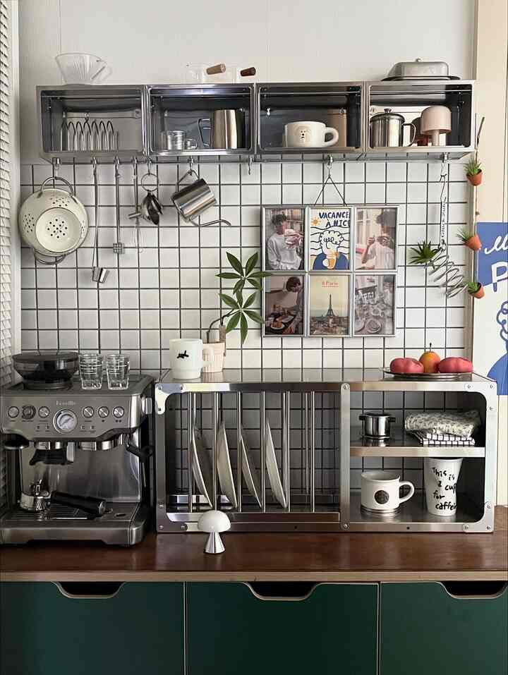 Silver and ivory toned kitchen space featuring stainless steel kitchen rack, coffee machine, plate organizer, and charming wall decor for a neat home cafe vibe