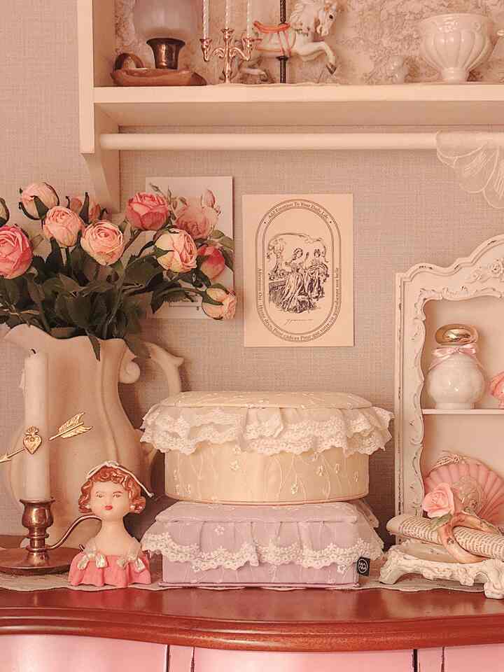 やわらかなベージュとピンクのトーンで彩られたフレンチカントリー風のインテリア、ヴィンテージのオブジェと花瓶が配置された温かみのある空間