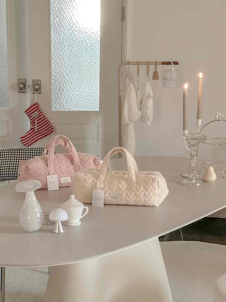 白とベージュのトーンのダイニング、シンプルなテーブルにキャンドルとオブジェが配置された自然な雰囲気のインテリア