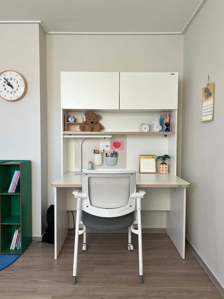 白とナチュラルカラーの子供部屋、シンプルで整然とした印象の机と椅子に可愛らしい小物が配置された雰囲気のあるインテリア