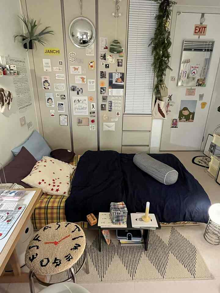 グレーとネイビーの色調が特徴の狭い寝室、ビルトインクローゼットと壁飾り、ウッドプラットフォームのベッドが落ち着いた雰囲気を演出するインテリア