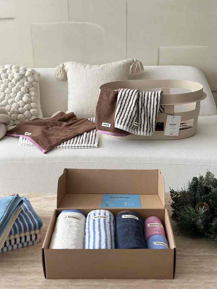 アイボリーとベージュの色調のリビング、快適なソファと様々な色のタオルが配置された温かみのあるインテリア