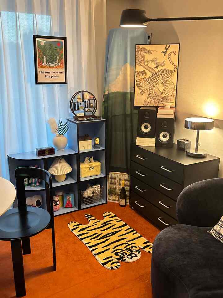 オレンジ色のカーペットと黒い家具が配置されたリビングルーム、暖かく居心地の良い雰囲気