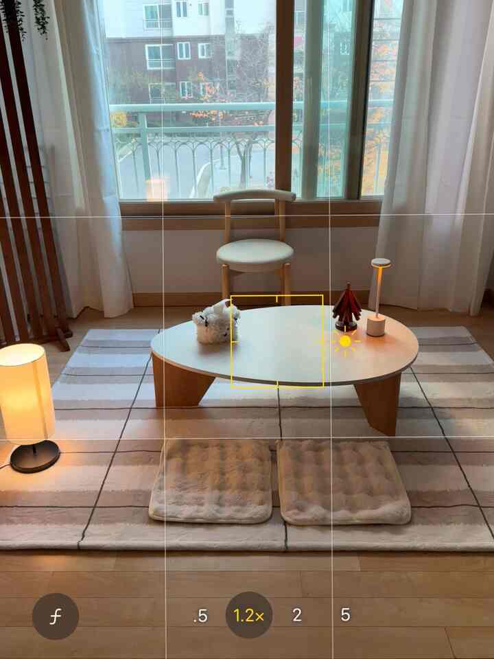 ナチュラルな色調のリビング、低い座卓とクッションが配置され、居心地の良い雰囲気のあるインテリア