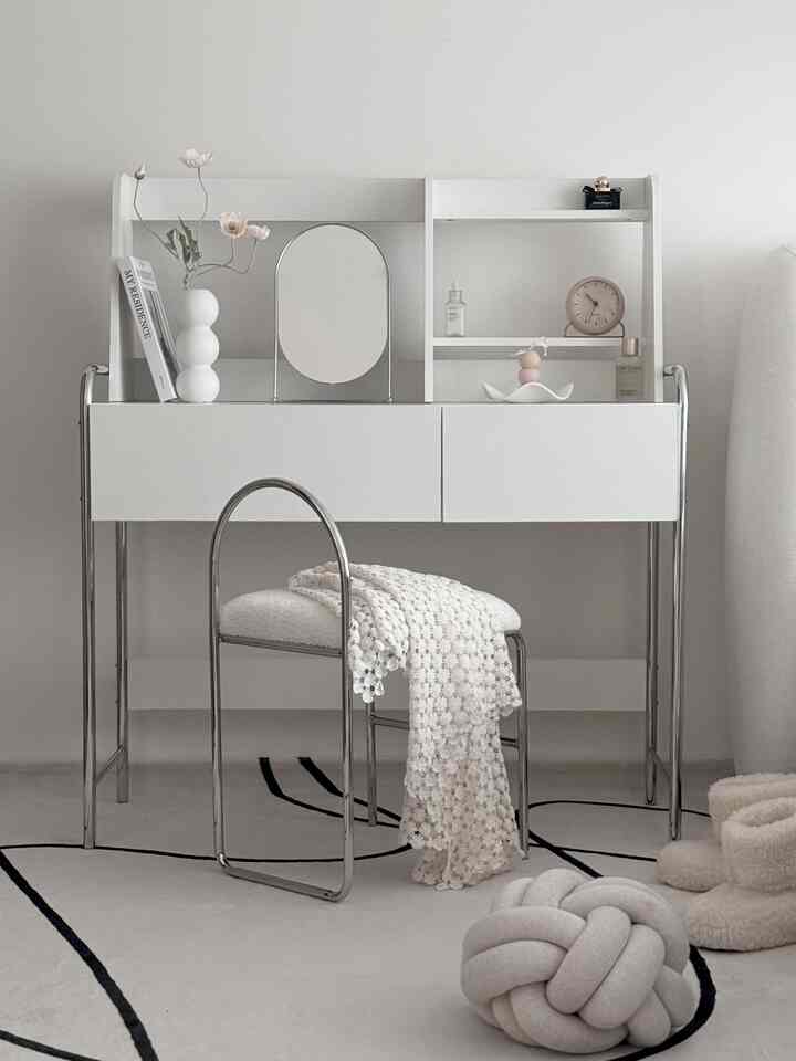 A simple Mid-Century Modern space featuring white vanity and chair with silver chrome frames