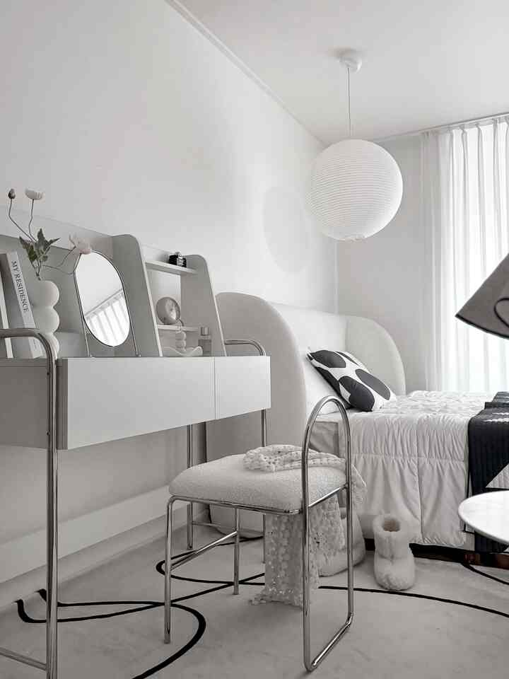 ホワイトとシルバーのトーンの寝室、ミッドセンチュリーモダンの化粧台とスツールが配置されたシンプルな空間
