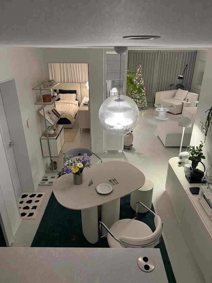 白とナチュラルカラーの1LDKキッチンリビング、丸みのある家具が配置された印象的な空間