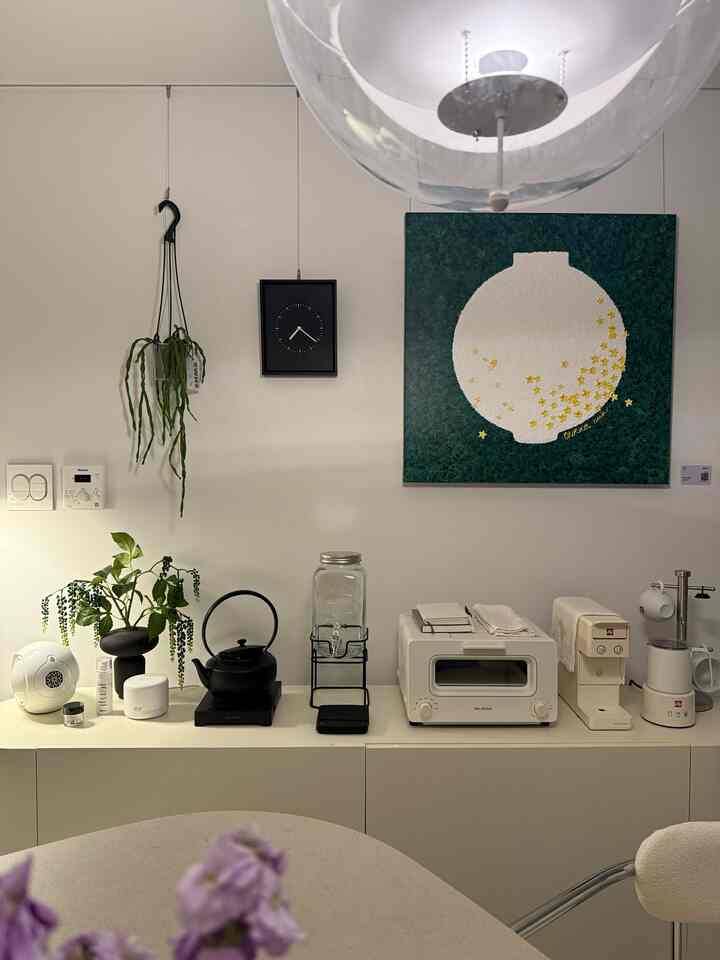 白とナチュラルカラーのキッチン空間、コーヒーマシンとトースターが整然と配置されたミッドセンチュリーモダンな雰囲気のあるインテリア