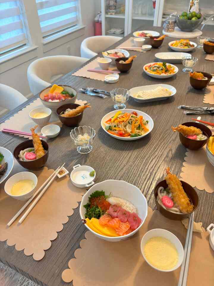 White and brown toned dining room featuring a large dining table with multiple dishes and tableware, creating a cozy atmosphere